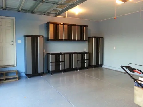 Silver metal and black metal frame cabinets installed in a garage by Pit Pro Handyman. We painted the walls light blue and polished the concrete floor
