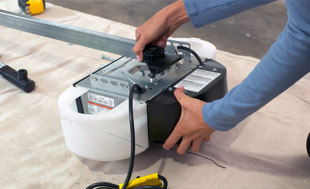 Image of man's arms inspecting a garage door opener motor housing in preparation for installation in Cranberry Township PA. 